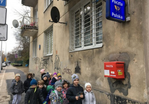 Dzieci stoją przy skrzynce pocztowej