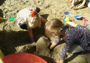 dwie dziewczynki bawią się w piaskownicy