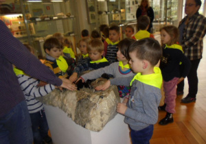dzieci dotykają skały