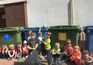 dzieci wrzucają swoje posegregowane śmieci 