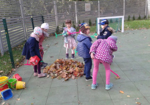 sześcioro dzieci grabi liście