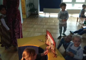 dziewczynka porusza lalkami jawajskimi w teatrzyku cieni