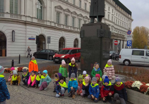 dzieci stoją pod pomnikiem Marszałka Józefa Piłsudskiego