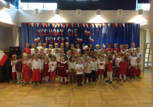 Dzieci ze wszystkich grup ubrane na biało-czerwono pozują do zdjęcia