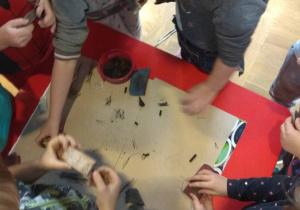 dzieci w zespole rysują węglem, ścierają skały za pomocą papieru ściernego