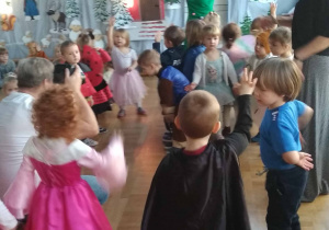 Dzieci w przebraniach tańczą na sali gimnastycznej