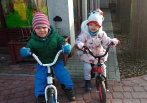 Dziewczynka i chłopiec na rowerkach biegowych