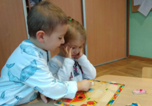 Dziewczynka z chłopcem układają puzzle