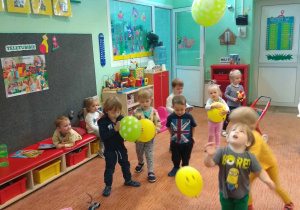 Dzieci bawią się balonami w sali