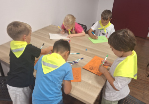 Dzieci siedza przy stole i rysują