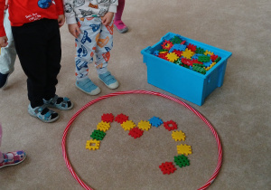 Dzieci w grupach układają z klocków cyfrę 3