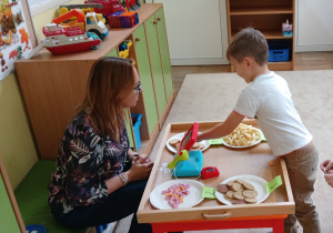 Chłopiec "kupuje" słodycze w sklepie