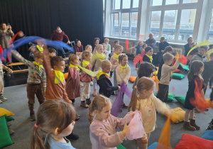 Dzieci tańczą w rytm muzyki wymachując chusteczkami