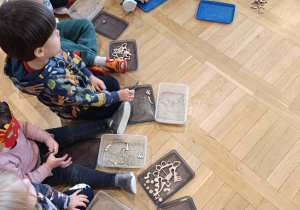 Dzieci odszukują kości w piasku