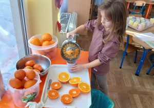 Dziewczynka wlewa sok do kubeczka