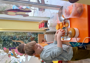 Chłopiec wyciska sok z pomarańczy