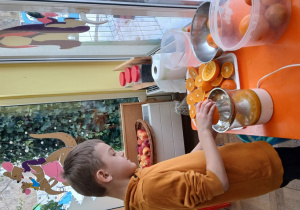 Chłopiec wyciska sok z pomarańczy