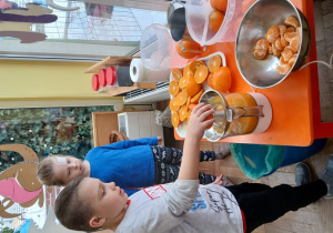 Chłopiec wyciska sok z pomarańczy