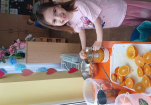 Dziewczynka wyciska sok z mandarynki