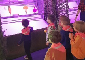 Dzieci rzucają piłkami aby strącić warzywa