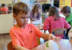 chłopiec ozdabia styropianowe jajka