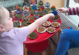 Dzieci ogladają domki z ogródkiem z rzeżuchy