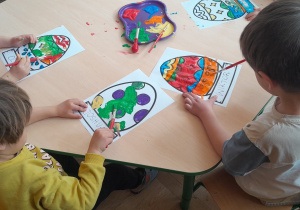 Dzieci kolorują farbami pisanki