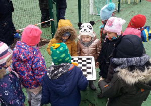 dzieci oglądają stolik do gry w szachy