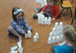 dziewczynki budują domki z kubków
