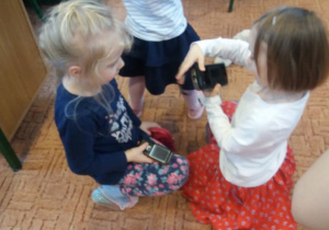 dziewczynki oglądają stare telefony