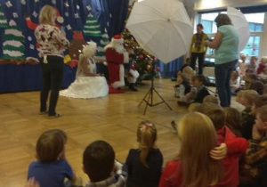 Dzieci siedzą i czekają na zdjęcie z Mikołajem