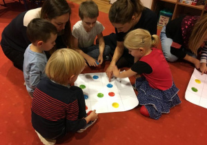 Dzieci z rodzicami układają kolorowe kółka